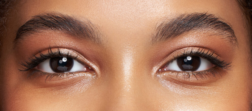 Close-up of a person's eyes with neutral makeup. Eyebrows are well-groomed.