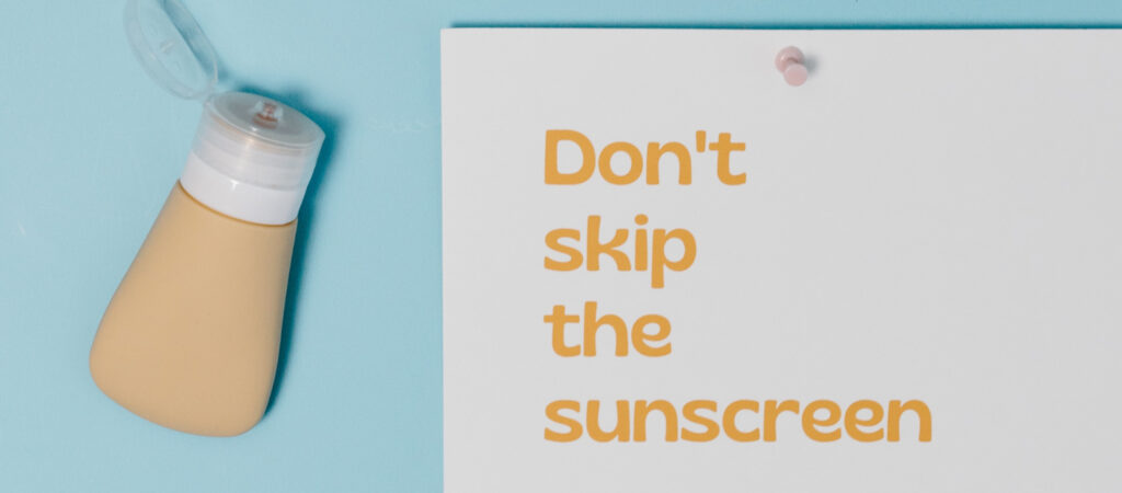 A bottle of sunscreen next to a paper with the text 