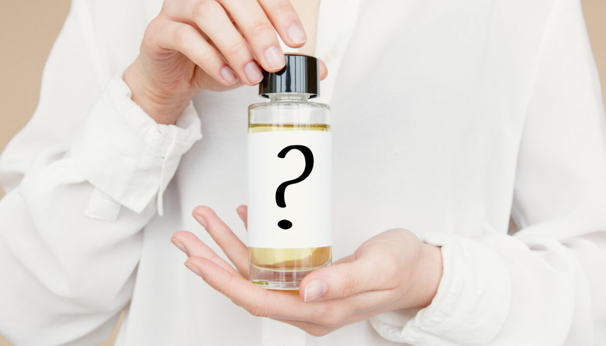 Person holding a small bottle with a question mark on the label, suggesting mystery or unknown contents.